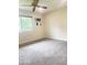 Well-lit bedroom offers neutral carpet and paint, a ceiling fan, and a large window at 12543 W Brandywine W Dr, Sun City West, AZ 85375