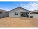 Spacious backyard with a patio, sliding glass doors, and a view of the desert landscape at 13171 W Buckskin Trl, Peoria, AZ 85383