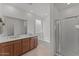 Bright bathroom features wood vanity, bathtub, glass-enclosed shower and large mirror at 13171 W Buckskin Trl, Peoria, AZ 85383