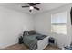 Cozy bedroom with ceiling fan, window, and comfortable bed with blue accents at 13171 W Buckskin Trl, Peoria, AZ 85383