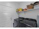 Functional laundry room featuring modern washer and dryer, storage shelf and entry door at 13171 W Buckskin Trl, Peoria, AZ 85383