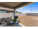 Inviting covered patio with outdoor seating and barbecue grill, overlooking the low maintenance backyard at 13171 W Buckskin Trl, Peoria, AZ 85383