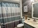 Cozy bathroom featuring a shower with striped curtain and wood-look accent wall at 13801 N 111Th Ave, Sun City, AZ 85351