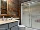 Bathroom showcasing a new vanity, custom sink, and shower with a glass door, with wood walls at 13801 N 111Th Ave, Sun City, AZ 85351