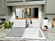 Bright kitchen sink area featuring stainless steel faucet, white backsplash, and granite countertop at 13801 N 111Th Ave, Sun City, AZ 85351