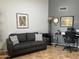 Comfortable office with neutral paint, a desk and chair, a gray couch and lots of natural light at 13801 N 111Th Ave, Sun City, AZ 85351