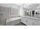 Bright bathroom features a soaking tub, granite counters, and stylish gray tiled walls at 14562 W Georgia Ave, Litchfield Park, AZ 85340