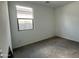 Neutral bedroom showcasing carpet flooring, a window for light, and electrical outlets along the walls at 15769 W Cheryl Dr, Waddell, AZ 85355