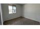 Cozy bedroom featuring carpet flooring, baseboard trim, and a bright window at 15769 W Cheryl Dr, Waddell, AZ 85355