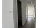 Hallway with storage and wood-look tile flooring, leading to rooms with neutral paint and black hardware at 15769 W Cheryl Dr, Waddell, AZ 85355