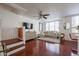 Open-concept living room featuring hardwood floors, a modern fan, and bright windows at 1701 E Colter St # 10, Phoenix, AZ 85016