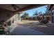 A covered patio with a ceiling fan overlooks the backyard and garden at 18457 W Ivy Ln, Surprise, AZ 85388