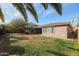 Large private backyard with mature landscaping, green grass and a cozy patio area at 18457 W Ivy Ln, Surprise, AZ 85388