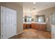 Bathroom featuring a large vanity with double sinks, mirrors, tile floor and a separate shower at 18457 W Ivy Ln, Surprise, AZ 85388