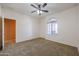 Bedroom featuring neutral walls, carpet flooring, ceiling fan and arched window at 18457 W Ivy Ln, Surprise, AZ 85388