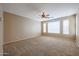 Spacious bedroom featuring a ceiling fan, plush carpeting and natural light at 18457 W Ivy Ln, Surprise, AZ 85388