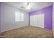 Bedroom featuring carpet flooring, purple walls, and closet with sliding doors at 18457 W Ivy Ln, Surprise, AZ 85388