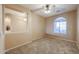 Comfortable bedroom with a ceiling fan, a large window, and carpeted flooring offering a cozy atmosphere at 18457 W Ivy Ln, Surprise, AZ 85388