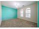 Bedroom with carpet flooring, blue accent wall, and natural light coming from two arched windows at 18457 W Ivy Ln, Surprise, AZ 85388