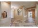 Entryway featuring decorative tile flooring, a front door, and an archway leading to a bathroom and other rooms at 18457 W Ivy Ln, Surprise, AZ 85388