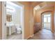 Hallway featuring an adjacent bathroom and a built-in cabinet adding convenience and style to the home at 18457 W Ivy Ln, Surprise, AZ 85388