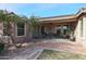 Covered patio with desert landscaping, tile flooring, and multiple potted plants at 18457 W Ivy Ln, Surprise, AZ 85388