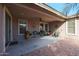 Cozy covered patio with brick flooring is perfect for outdoor living and relaxing in style at 18457 W Ivy Ln, Surprise, AZ 85388