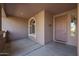 The covered front porch welcomes visitors with an arched window and lovely door at 18457 W Ivy Ln, Surprise, AZ 85388