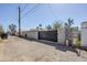 A large metal gate is set within a block wall, providing secured access to the back alleyway at 1926 W Holly St, Phoenix, AZ 85009