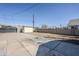 Backyard with concrete and gravel space surrounded by block wall and a large storage shed under a blue sky at 1926 W Holly St, Phoenix, AZ 85009