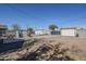 Backyard featuring gravel and concrete space with storage sheds and block wall under a clear blue sky at 1926 W Holly St, Phoenix, AZ 85009