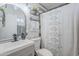 Bathroom featuring a round mirror, single sink vanity, open shelving with decor and decorative shower curtain at 1926 W Holly St, Phoenix, AZ 85009