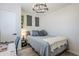 Bedroom featuring wood-look floors, modern light fixture, desk space, and bed with blue pillows at 1926 W Holly St, Phoenix, AZ 85009