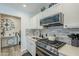 Updated kitchen featuring white cabinets, a stylish backsplash, and stainless steel appliances at 1926 W Holly St, Phoenix, AZ 85009