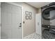Functional laundry room with a stacked washer/dryer, storage cabinet, and patterned flooring at 1926 W Holly St, Phoenix, AZ 85009