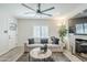 Bright living room featuring a modern ceiling fan, stone fireplace, and stylish furnishings at 1926 W Holly St, Phoenix, AZ 85009