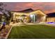 Spacious backyard with a covered patio, outdoor dining area, sparkling pool, and verdant artificial lawn at 20729 E Canary Way, Queen Creek, AZ 85142