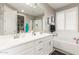 Well-lit bathroom with double sinks, a large mirror, white cabinets and a separate bathtub and shower at 20729 E Canary Way, Queen Creek, AZ 85142