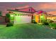Attractive home exterior showcasing a two-car garage, updated landscaping, and decorative lighting at 20729 E Canary Way, Queen Creek, AZ 85142
