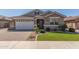 Charming single-story home with well-manicured lawn and brick-paved driveway leading to an attached two-car garage at 20729 E Canary Way, Queen Creek, AZ 85142