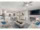 Open-concept living area with tiled flooring, a ceiling fan, modern furniture, and an electric fireplace with a television above at 20729 E Canary Way, Queen Creek, AZ 85142