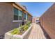 View of a side yard with a garden bed and paver pathway leading to a wooden gate at 20729 E Canary Way, Queen Creek, AZ 85142