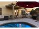 Charming backyard patio area with a grill, dining set, and cozy seating under a covered porch, adjacent to a refreshing pool at 21630 N 30Th Ln, Phoenix, AZ 85027