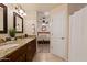 Bathroom with dual sinks, granite countertops, and an adjacent bedroom at 21630 N 30Th Ln, Phoenix, AZ 85027