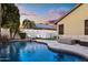 A serene backyard oasis featuring a sparkling pool, cozy seating, and a modern fire pit, perfect for evening relaxation at 21630 N 30Th Ln, Phoenix, AZ 85027