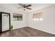 Simple bedroom featuring a ceiling fan, wood floors, and large windows at 2324 N 40Th St, Phoenix, AZ 85008
