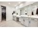This bathroom features dual sinks, and a door leading to a large walk-in closet at 24441 N 142Nd Dr, Surprise, AZ 85387