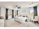 This primary bedroom features two windows, a ceiling fan and light grey colored carpet at 24441 N 142Nd Dr, Surprise, AZ 85387