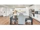 Dining area featuring a dark wood table, gray upholstered chairs, and open access to a modern kitchen with island at 24441 N 142Nd Dr, Surprise, AZ 85387