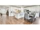 Open kitchen with white cabinets, a granite island, stainless appliances, and adjacent dining area with gray upholstered chairs at 24441 N 142Nd Dr, Surprise, AZ 85387
